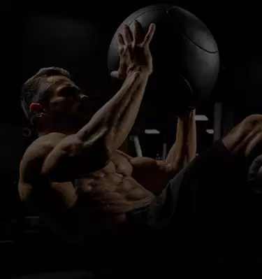 A man performing abdominal presses with a medicine ball