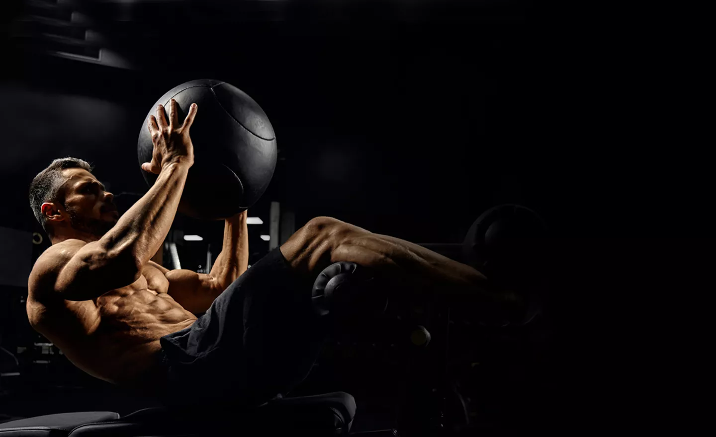 A man performing abdominal presses with a medicine ball.